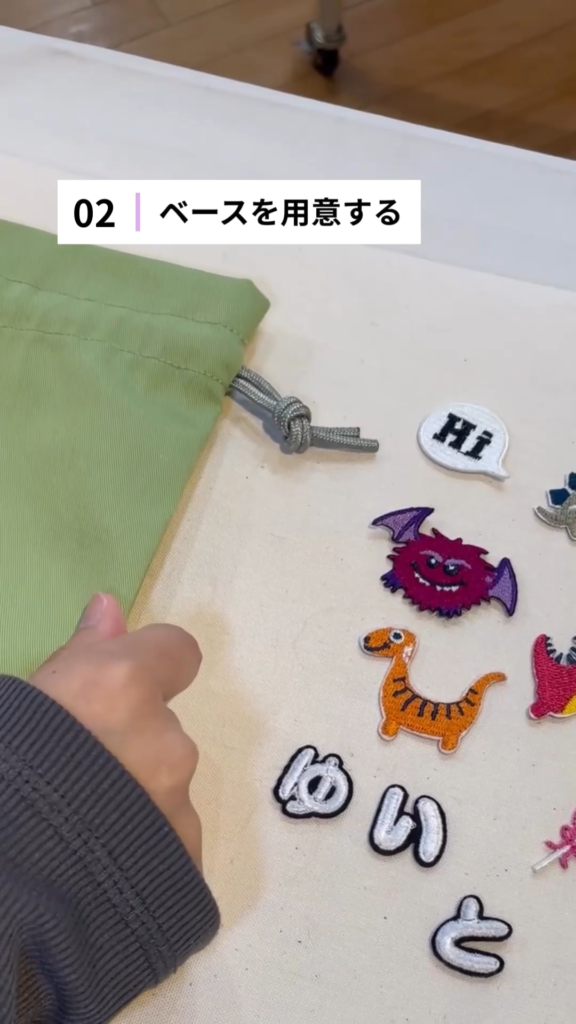 韓国ワッペンと緑色の巾着袋を使ってワッペンワークをしている