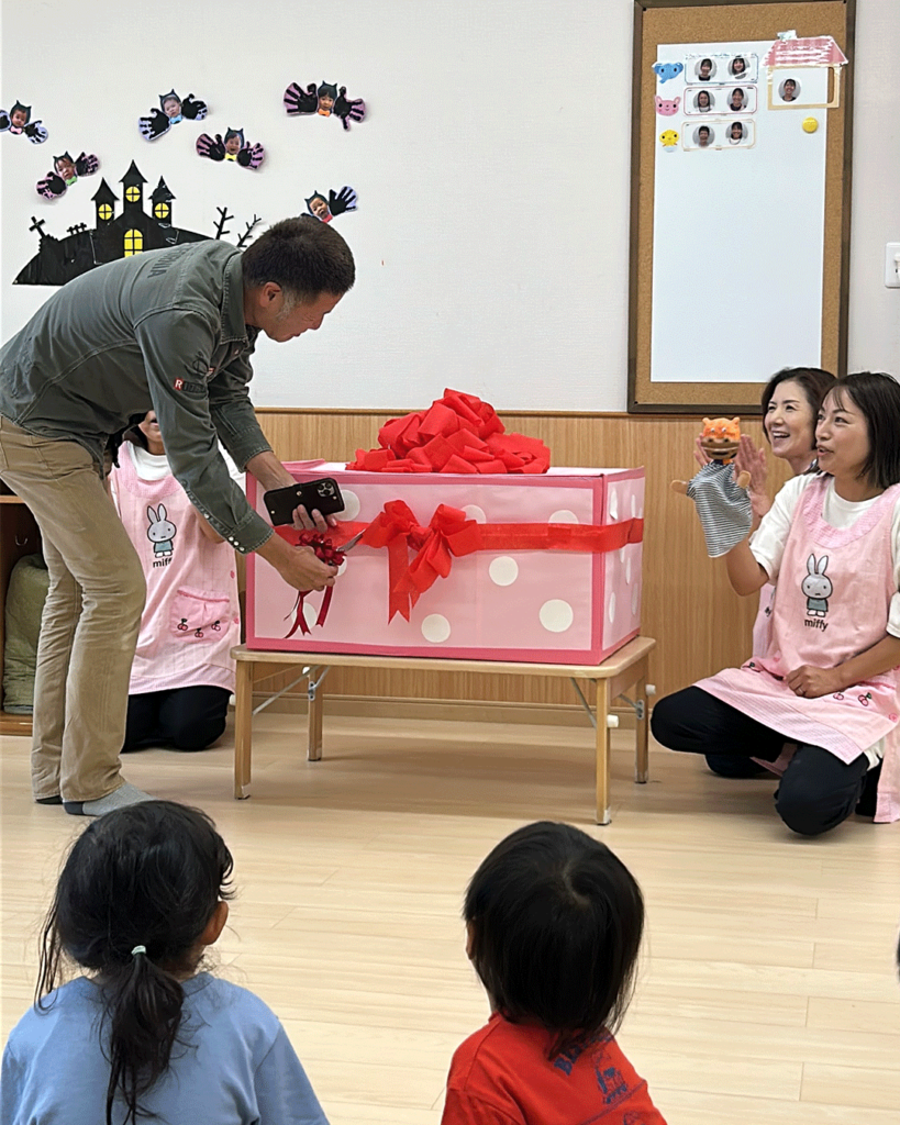 カバンストリート保育園運営会社社長がプレゼント箱のリボンカットの様子
